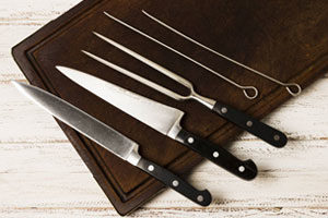Deux couteaux et des piques à brochette sur une planche à coupe
